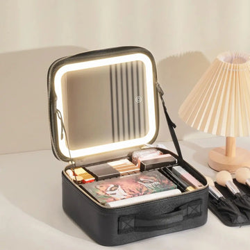 Trousse de maquillage LED noire ouverte sur une coiffeuse, le miroir plein couvercle éclairé par son anneau LED
