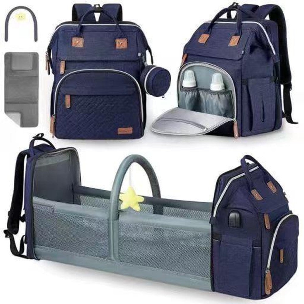Sac à dos Mommy bleu marine montré fermé, ouvert au niveau des poches pour bouteilles et déplié dans le berceau avec l'arche à jouets